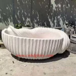 Conch shaped white marble bathtub